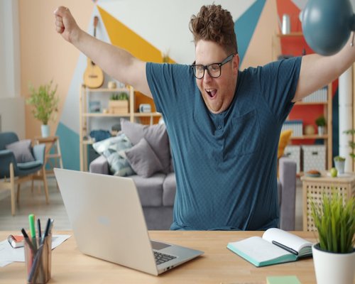 Person stretching arms gently at a small desk at home